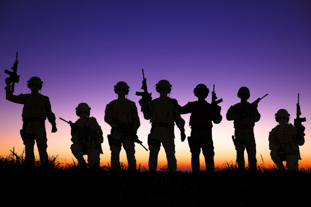 soldaten silhouetten tegen de achtergrond van een zonsondergang of zonsopgang  - Foto, afbeelding