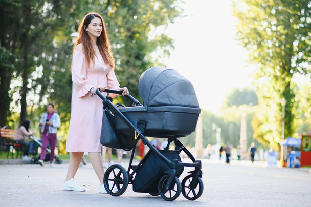 Mother with baby carriage in the park - Foto, Imagem
