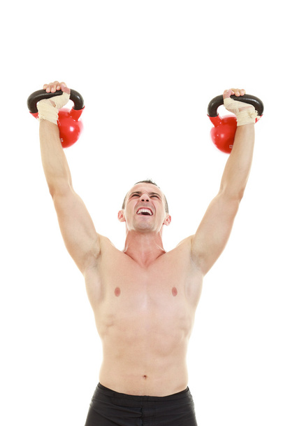 fitness athletic man holding and lifting high up red kettlebells - Foto, imagen