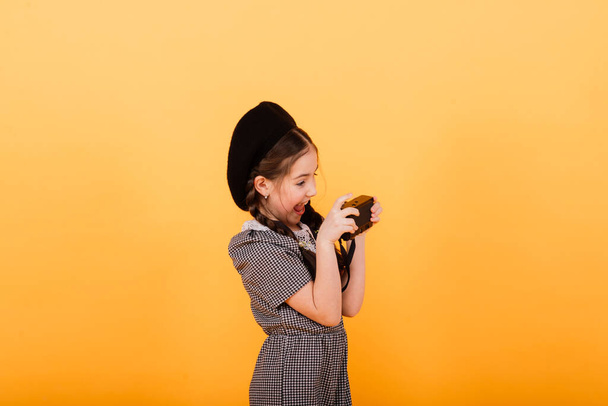 Cute little girl wearing bright stylish clothes on a yellow colorful background - Photo, Image