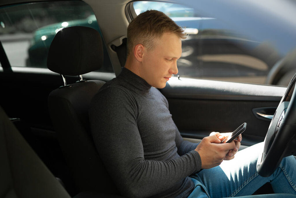 young businessman driving a car with a phone  - Foto, imagen