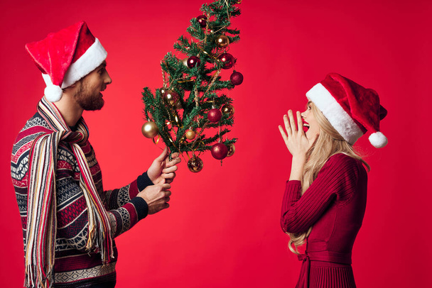 alegre joven pareja vacaciones navidad regalo decoración rojo fondo - Foto, Imagen
