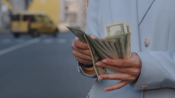 Close-up vrouwelijke handen tellen dollarbiljetten buiten op de verkeersweg. Zakenvrouw die geld bij zich heeft. Geld berekening in de stad. Meisje met salaris. Dame met betaalmiddelen - Video