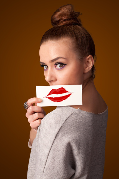 Happy pretty woman holding card with kiss lipstick mark - Photo, Image