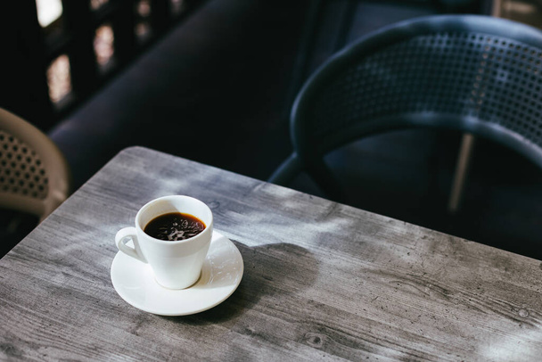 Cup of black coffee on a rustic wooden table in a street cafe. Place for text. - Photo, Image