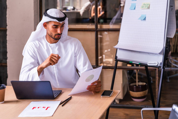 Homme d'affaires arabe portant des émirats traditionnels kandura au travail dans une entreprise internationale de Dubaï - Photo, image
