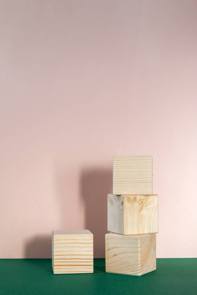 wooden cubes still life against pale pink and emerald green background - Φωτογραφία, εικόνα