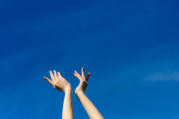Bárcsak megérinthetnénk az eget, a nő kinyújtja a kezét a kék égig. Szabadság és tavasz koncepció - Fotó, kép