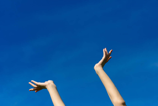 Ik wou dat we de hemel konden raken, vrouwen die hun handen naar de blauwe lucht strekken. Vrijheid en lente concept - Foto, afbeelding