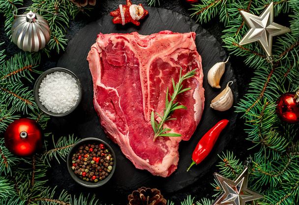 steak de bœuf cru aux épices et herbes sur fond noir - Photo, image