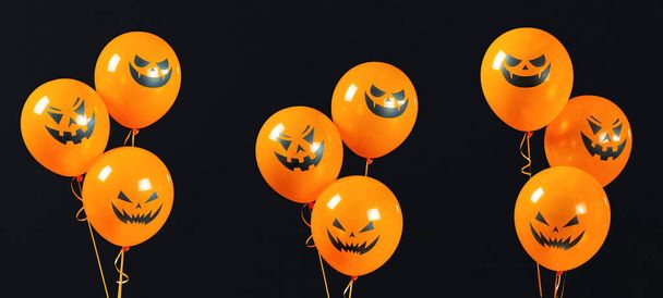 Букеты шариков Хэллоуина установлены изолированно на черном текстурированном фоне. Оранжевые шарики со страшными тыквенными лицами наполнены гелием. Декорации для Хэллоуина. - Фото, изображение