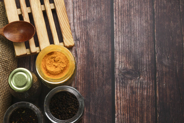 A top view of various seasonings and a wooden spoon on a table - Photo, Image