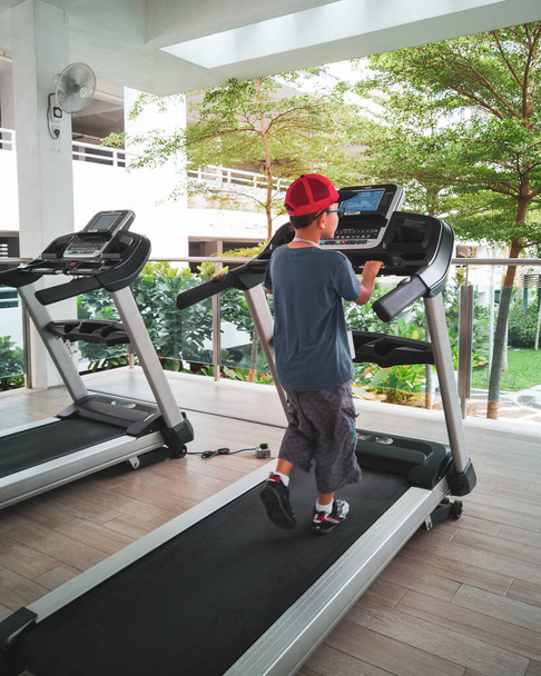 předpubertální dítě trénuje na běžeckém pásu ve fitness studiu, tělocvična třída děti koncept - Fotografie, Obrázek