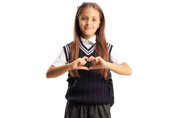 Portrait of a schoolgirl gesturing a heart sign with hands isolated on white background - Foto, Bild