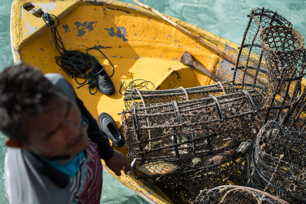 Pièges à poissons rouillés sur le bateau avec l'eau cristalline en arrière-plan à Semporna, Sabah. - Photo, image