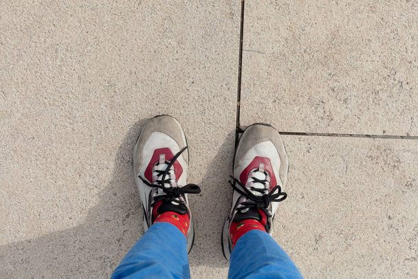 female feet in sneakers on the alley in the park - Photo, Image