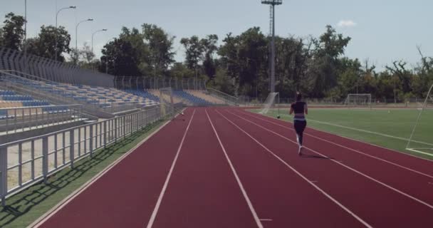 Αθλητική νεαρή γυναίκα τρέχει στο γήπεδο - Πλάνα, βίντεο