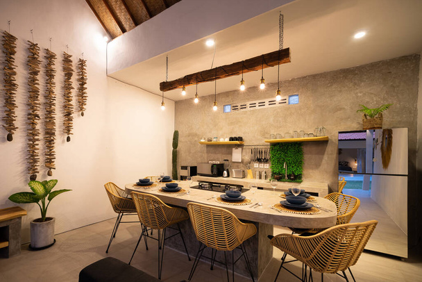 Modern mutfak ve aletler. İnce ışıklandırma. Parlatılmış betondan yapılmış yemek masası.. - Fotoğraf, Görsel