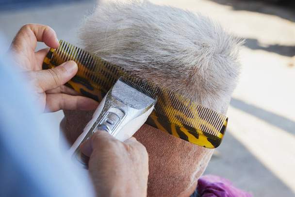 Top View Fryzjer lub fryzjer Użyj Clipper i grzebień Cut lewej stronie Starzec włosy w domu fryzjer - Zdjęcie, obraz
