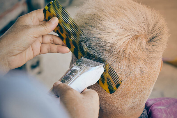 Friseur oder Friseur verwenden Haarschneidemaschine und Kamm schneiden das linke Haar des alten Mannes zu Hause Friseursalon in Vintage-Ton - Foto, Bild