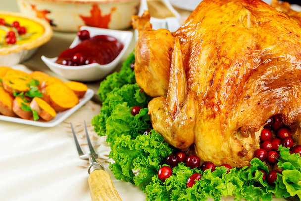 Thanksgiving dinner table with roasted turkey with cranberry sauce and yam. Close up. - Fotó, kép