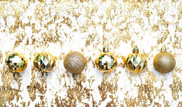 Golden Christmas balls, flat lay on the golden background.  Winter holidays concept. - Photo, Image