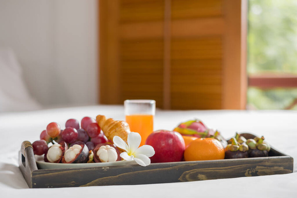 Focus on fruit. In a hotel room with fruit, place a tray on the bed to welcome the arrival of VIP guests. - Photo, image