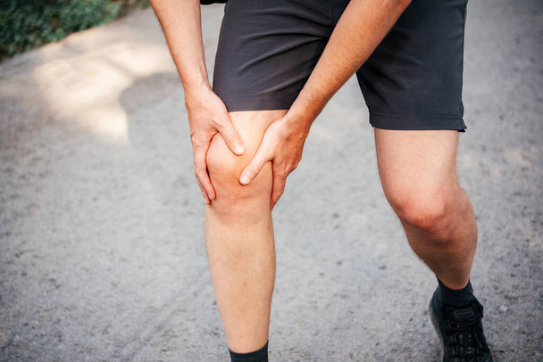 Un homme ayant un genou lors de la course ou du jogging, blessures au genou chez les athlètes - Photo, image