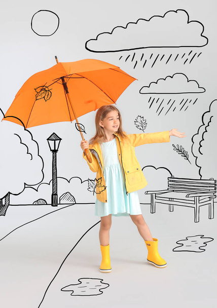 Cute little girl in raincoat and with umbrella in drawn park on grey background. Autumn concept - Photo, Image