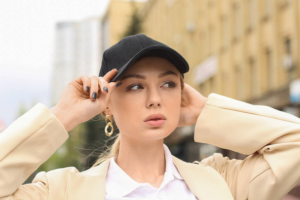 Pretty woman wearing baseball cap in city - Фото, изображение