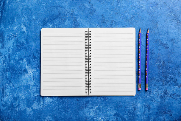 Cuaderno y lápices sobre fondo de color - Foto, imagen