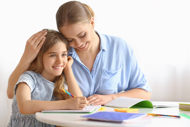 Bambina con sua madre che fa lezioni a casa - Foto, immagini