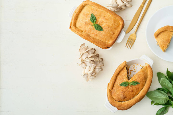 Випічка страв і тарілок зі смачним грибним пирогом на білому дерев'яному фоні
 - Фото, зображення