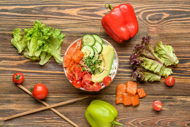 Composition with tasty poke bowl and ingredients on wooden background - Photo, Image