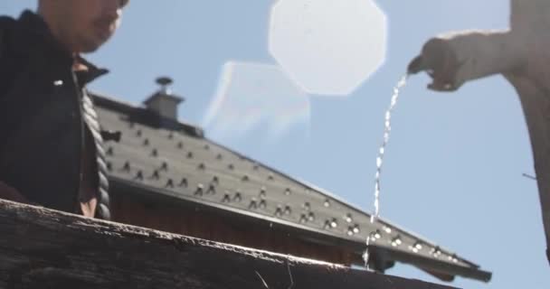 Im Gegenlicht zu sehende Aufnahmen eines durstigen Mannes, der an einem heißen, sonnigen Tag mit seinen Händen Wasser aus einem Wasserhahn trinkt - Filmmaterial, Video