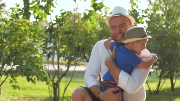 Vaderdag, vrolijke vader knuffelt zijn zoon en lacht op een wandeling, gelukkig gezin, van een jongen houden, kleuter met een ouder in het park, een dag vrij doorbrengen met een kind, voogdij over een baby, liefhebbende kinderen - Video