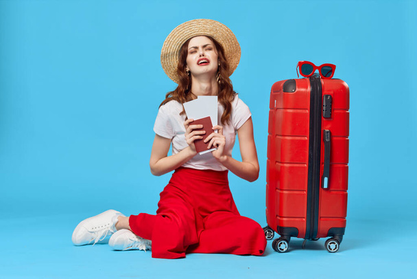 vrouw met rood kofferpaspoort en vliegtickets vakantiebestemming - Foto, afbeelding