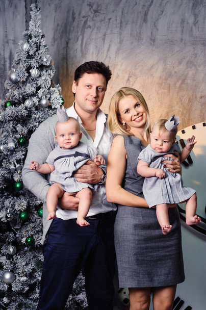 A happy big family with twin children in the New Year's interior of the house on the background of a Christmas tree. - Foto, Bild