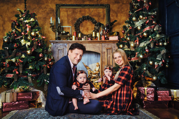 A happy big family with their children in the New Year's interior of the house by the fireplace next to the Christmas tree. - Foto, Bild