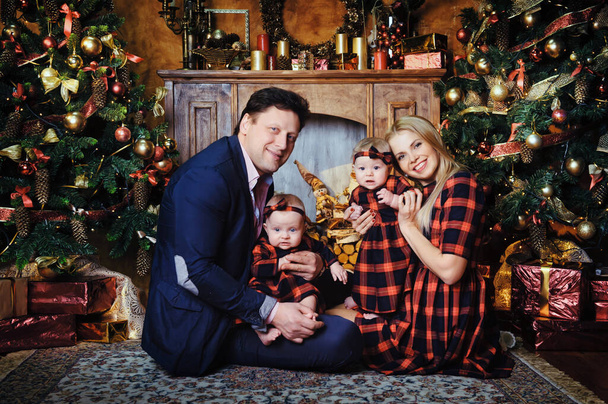 Una gran familia feliz con sus hijos en el interior de Año Nuevo de la casa junto a la chimenea junto al árbol de Navidad. - Foto, Imagen