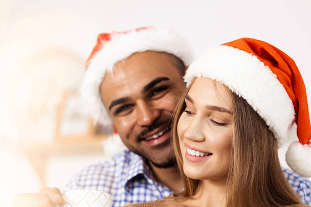 Cheerful attractive happy couple in Santa hats - Фото, изображение
