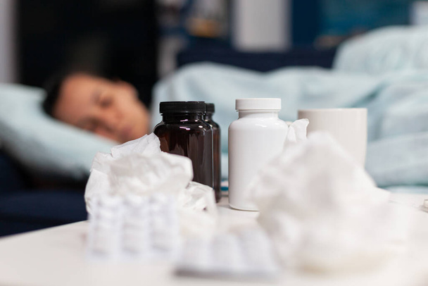 Close up of bottles and pills for sick woman with virus - Photo, Image