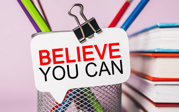 Text Believe you can on a white sticker with office stationery background. Flat lay on business, finance and development concept - Φωτογραφία, εικόνα