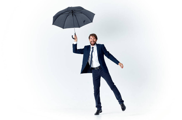 スーツ姿の男が傘を手にエレガントなスタイルの雨の中 - 写真・画像