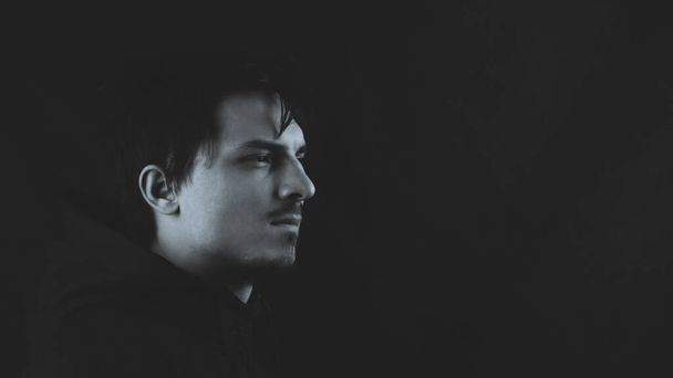 Profile view of young man in the dark. male portrait. black and white - Foto, Bild