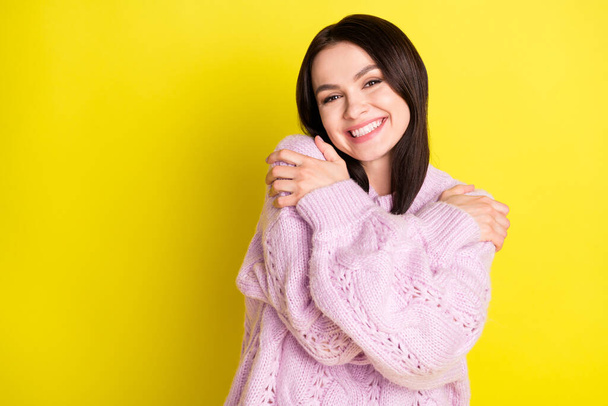 Photo of sunny cheerful brown hairdo lady hug herself wear pink sweater isolated on vivid yellow color background - Photo, Image