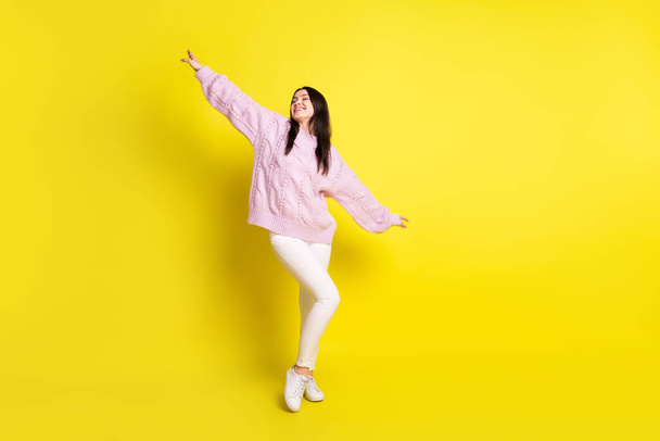 Full body photo of millennial brown hairdo lady dance wear pink sweater pants sneakers isolated on yellow color background - Φωτογραφία, εικόνα