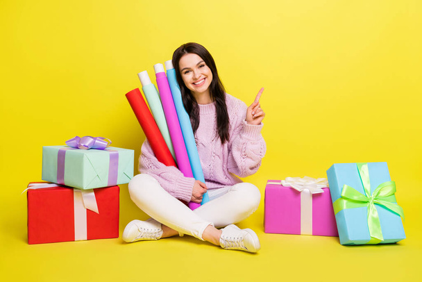 Full length photo of sweet millennial lady hold paper for present point empty space wear sweater pants isolated on yellow background - Фото, зображення