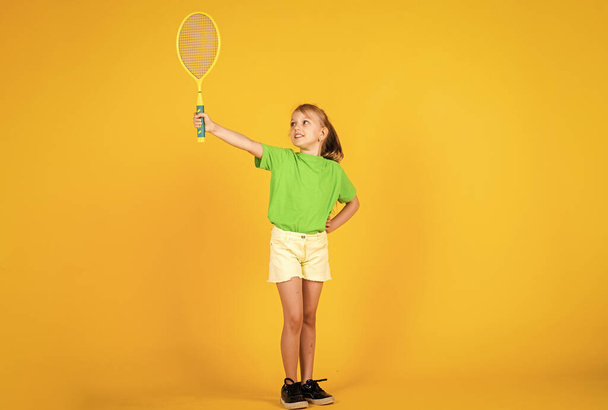 cute child play tennis or badminton. active way of life. full of energy. beautiful teen girl with tennis racquet. kid sport fashion style. fitness and health. happy childhood. Sport is our life - Foto, Imagen