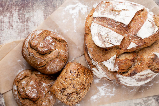 Freshly baked bread on dark gray kitchen table, top view. - Foto, Bild